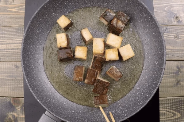 Тофу нарезать небольшими прямоугольниками. Обжарить на смеси растительного и кунжутного масла на хорошо разогретой сковороде до золотистой корочки. Переложить на бумажное полотенце.