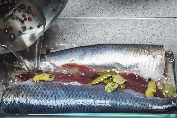  Выложить подготовленную селедку в стеклянную форму или пищевой пластиковый контейнер. Залить рассолом.