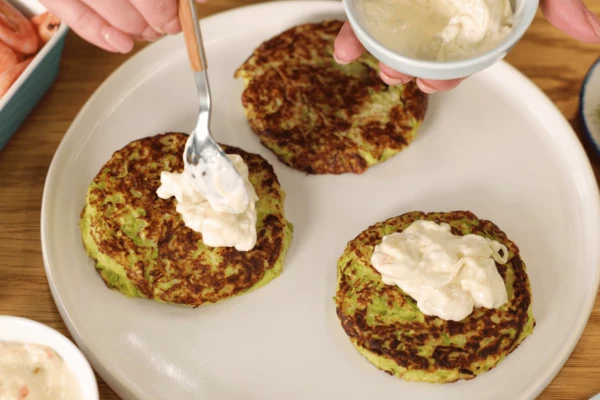 Готовые оладьи выложить на тарелку для подачи, полить соусом с креветками. 