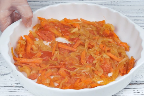 На разогретой с растительным маслом сковороде обжарить лук, морковь, помидоры примерно 7 минут, добавить специи, соль,  переложить в форму.