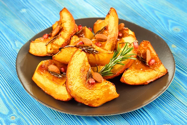 Подать сладкую тыкву с ядрами ореха и веточкой свежего розмарина.