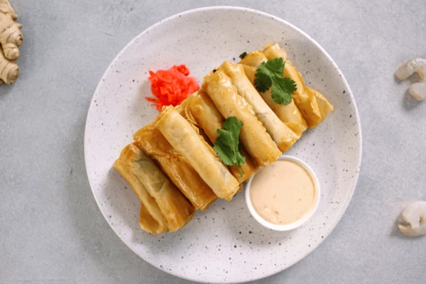 На тарелку для подачи выложить креветки. Оформить маринованным имбирем и кинзой. Подавать с соусом. 
