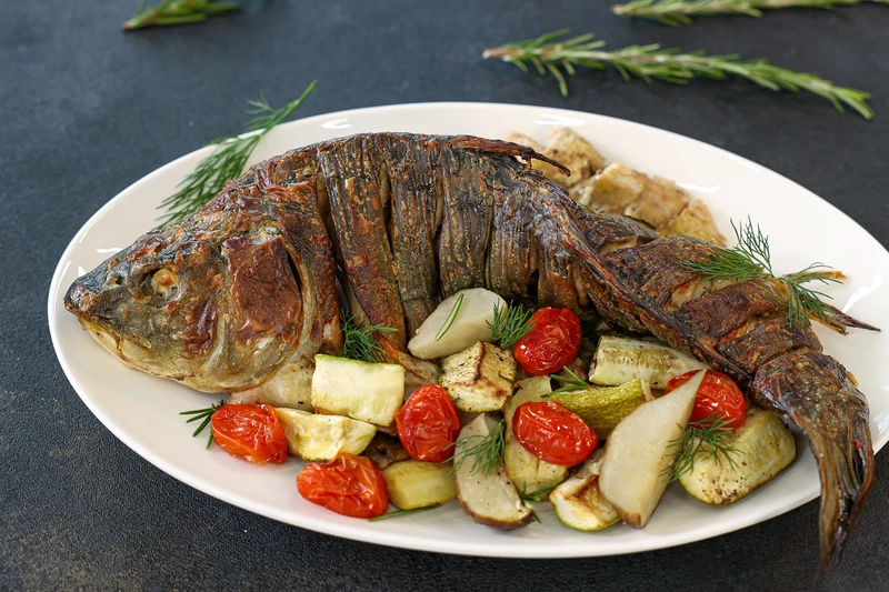 Карп, запечённый на подушке из овощей