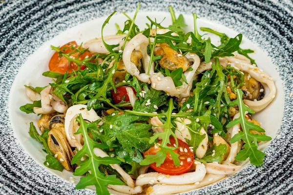 Хорошо перемешать, выложить в тарелку, сверху морепродукты, украсить кунжутом.