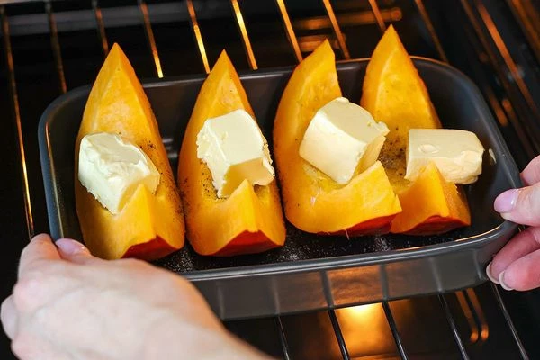 Выложить в форму для запекания, положить кусочек сливочного масла на каждую дольку, посолить, поперчить, запекать при 180˚C до готовности (25-30 минут). 